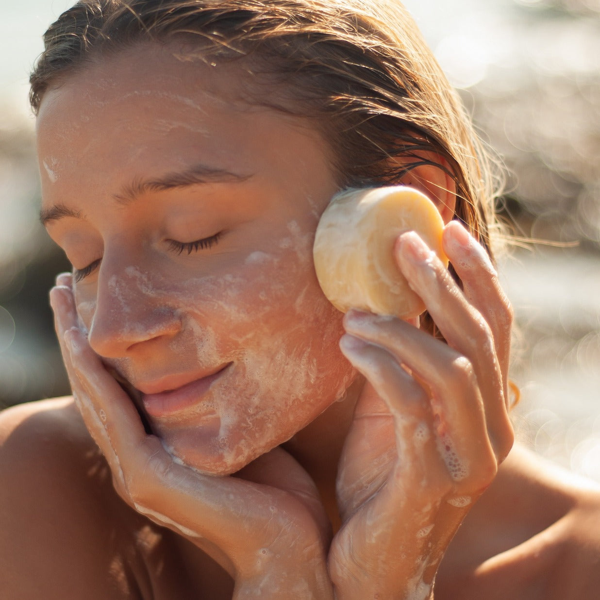 Mädchen mit eingeseiftem Gesicht und Stück Aloe Vera Seife
